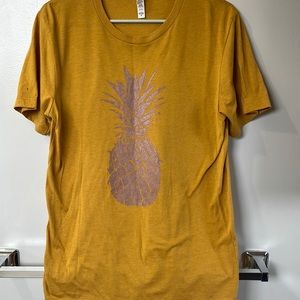 Mustard color tee with rose gold pineapple.